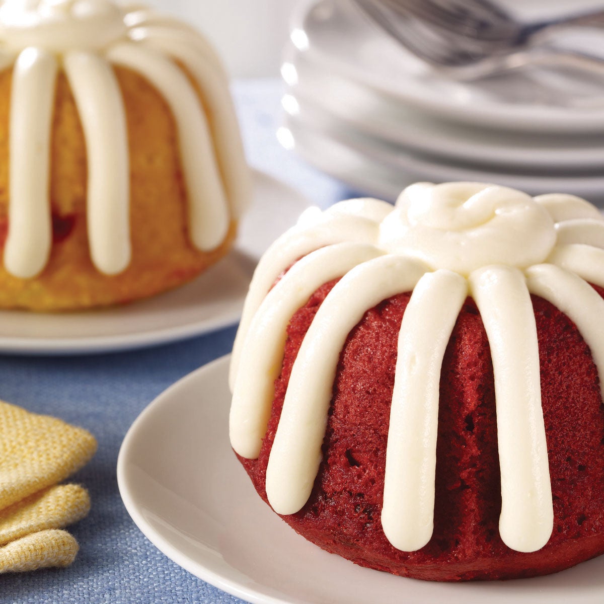 Nothing Bundt Cakes Bundtlets topped with signature frosting, served on plates.
